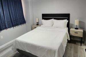 una camera da letto con un letto grande con lenzuola e cuscini bianchi di Urban Hideaway - 201 a Tulsa