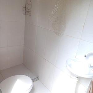 Un baño blanco con inodoro y lavabo. en Casa do alecrim, en Nova Friburgo 15 fotos más