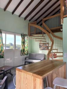 a living room with a couch and a staircase at Appartement moderne à Vieux-Habitants, 80 m², terrasse in Beaugendre