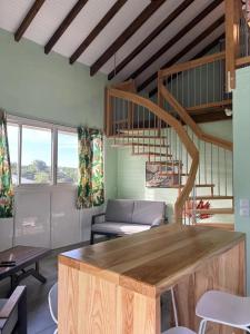 a living room with a couch and a spiral staircase at Appartement moderne à Vieux-Habitants, 80 m², terrasse in Beaugendre
