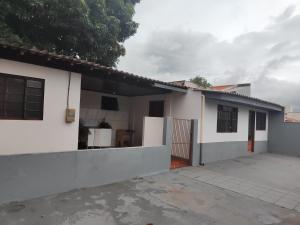 a house with white walls and a driveway at Pousada Canto dos pássaros in Cianorte