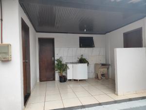 an empty room with a kitchen and a door at Pousada Canto dos pássaros in Cianorte