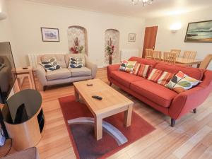 un soggiorno con divano rosso e tavolino da caffè di Molly's Cottage a Grasmere