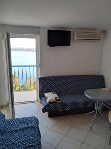 a living room with a couch and a table and a window at Apartman 98, free parking in Karlobag