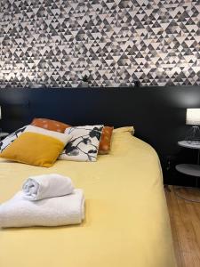 a bed with two towels on top of it at Le Saint Vincent Calme & Confort in Vannes