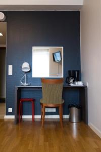 a chair in a room with a blue wall at Torget Aparthotel in Pori