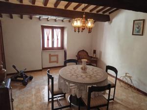 a dining room with a table and chairs and a chandelier at la casina della bubbolina in Semproniano