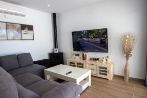 a living room with a couch and a tv at EL ENCANTO Chiclana II in Chiclana de la Frontera