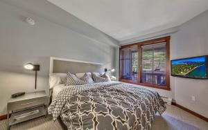ein Schlafzimmer mit einem Bett und einem großen Fenster in der Unterkunft Palisades Village ski in ski out Mountain Retreat in Olympic Valley
