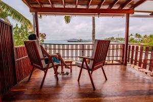 a person sitting in chairs on a porch looking out at the ocean at La Casa de Marita in Puerto Villamil +51 photos