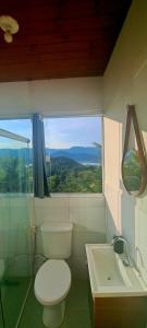 a bathroom with a toilet and a sink and a window at Suíte em casa particular Sidi & Val - Soul Almada - Praia da Almada Ubatuba in Ubatuba