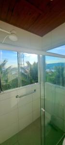 a bathroom with a glass shower with a large window at Suíte em casa particular Sidi & Val - Soul Almada - Praia da Almada Ubatuba in Ubatuba