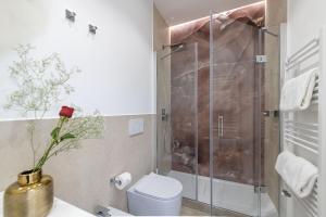 e bagno con doccia, servizi igienici e fiore. di St Peter Twelve a Roma