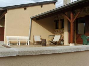 a porch with two benches and chairs in front of a building at La maison du vigneron in Ternand