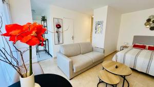 a living room with a couch and a bed at Magnifique studio le France in Mandelieu-la-Napoule +2 photos