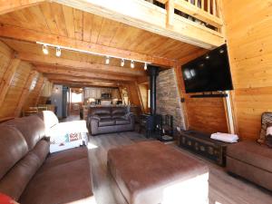 ein Wohnzimmer mit Ledermöbeln und einem Flachbild-TV in der Unterkunft Ski Lee Retreat in Brian Head