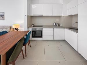 a kitchen with white cabinets and a wooden table at Lavander Bay F04 in Donji Morinj