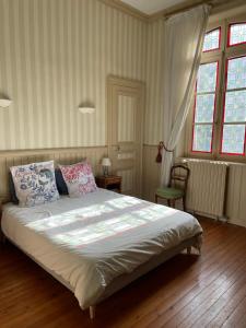 a bedroom with a large bed and a window at Le Jardin du Clocheton, jardin et parkings privés, centre Etretat in Étretat