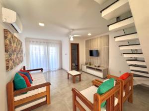 ein Wohnzimmer mit Sofa und Tisch in der Unterkunft Apto para temporada em Arraial D'ajuda in Porto Seguro