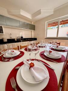 einen Tisch mit roten und weißen Platten und Weingläsern in der Unterkunft Apto para temporada em Arraial D'ajuda in Porto Seguro