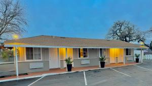 a building with two potted plants in a parking lot at Budget Motel in Gilroy +23 photos