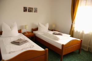two beds in a hotel room with towels on them at Hotel Buchrain in Göppingen
