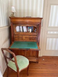 a wooden desk with a chair in a room at Le Jardin du Clocheton, jardin et parkings privés, centre Etretat in Étretat