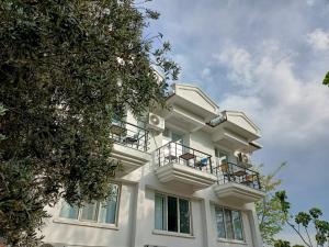 a white building with balconies on the side of it at Gökçeada Helios Pansiyon in Gokceada Town +80 photos