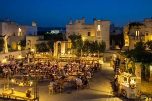 a group of people sitting at tables in front of a castle at Borgo Egnazia in Savelletri di Fasano