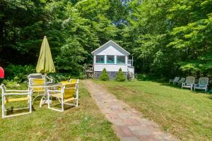 une arrière-cour avec une table et des chaises ainsi qu'une maison dans l'établissement Lake Stinson Cottage with Sunroom and Shared Dock!, à Rumney