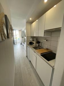 eine Küche mit weißen Schränken und einem Holzboden in der Unterkunft La Casita de Niagara in San Miguel de Abona