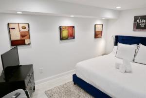ワシントンにあるStylish & Modern Apt Shaw PKINGのベッドとテレビのある白い寝室