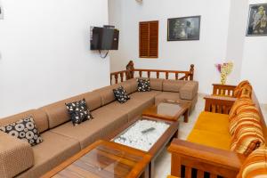 a living room with a couch and tables at Nandana Guest House in Watagedaramulla