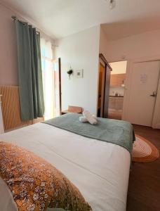 ein Schlafzimmer mit einem großen Bett mit grünen Vorhängen in der Unterkunft "petillat"-Superbe studio meublé 3 étoiles in Vichy