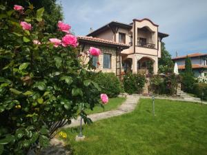 a large house with pink roses in the yard at къща за гости villa Jurta in Avren +77 photos