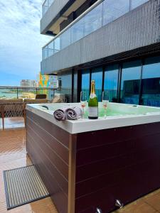 a hot tub with a bottle of wine and two glasses at Landscape@UrbanBeach -200 m² de puro luxo in Fortaleza