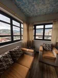 a living room with a couch and two windows at El Monasterio in Quito