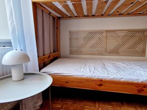 ein Bett mit einem hölzernen Kopfteil in einem Zimmer in der Unterkunft Kwatera Słowackiego - tanie spanie centrum bezpłatny parking in Lyck