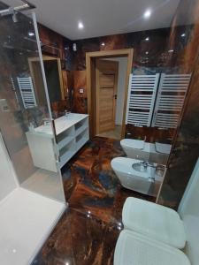 a bathroom with two sinks and two toilets at Apartamenty Noclegowe U Bartosza in Odrzechowa +18 photos