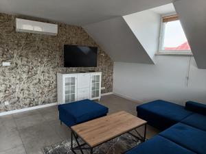 a living room with a couch and a table and a tv at Apartamenty Noclegowe U Bartosza in Odrzechowa