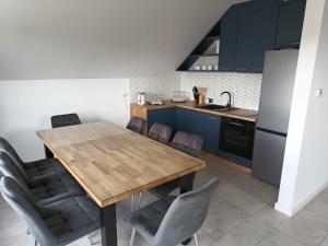a kitchen with a wooden table and chairs at Apartamenty Noclegowe U Bartosza in Odrzechowa