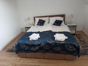 a bedroom with a bed with two towels on it at Apartamenty Noclegowe U Bartosza in Odrzechowa