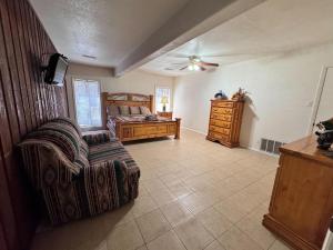 a bedroom with a bed and a chair and a dresser at River Hideout: One Bedroom Duplex Cottage ON THE RIVER!! in Ruidoso