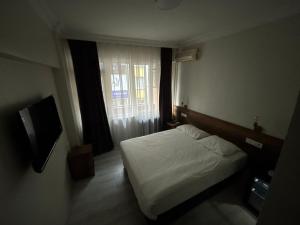 a small bedroom with a bed and a window at Altinnal Hotel in Kocaeli
