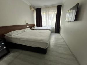 a hotel room with two beds and a window at Altinnal Hotel in Kocaeli