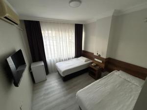 a hotel room with two beds and a window at Altinnal Hotel in Kocaeli +6 photos