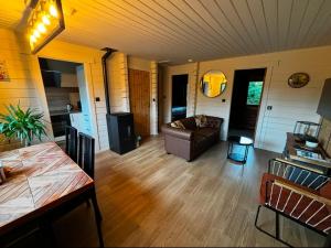 a living room with a couch and a table at Gîtes Douillets : Chalet sur Pilotis in Houyet