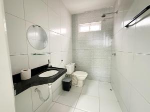 Un baño blanco con lavabo e inodoro. en Hotel Oiticica, en Fortaleza 47 fotos más