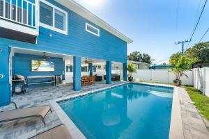 una piscina frente a una casa azul en 152 Steps to the Beach! Heated Pool - Steps Away - Roelens, en Fort Myers Beach