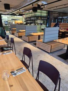 a row of wooden tables and chairs in a restaurant at Corso Harrachov Apartment 303 in Harrachov